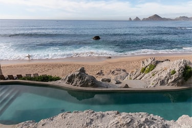Surfer relaxing near a saltwater pool overlooking the ocean