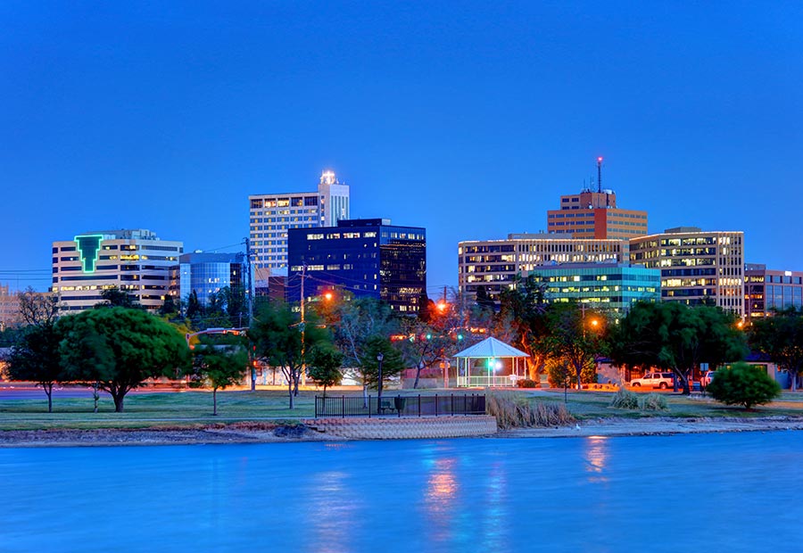 Downtown Midland skyline reflected on a lake at dusk.