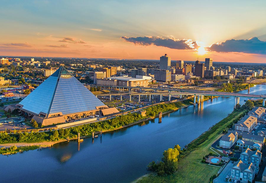 Memphis Pyramid and downtown skyline along the Mississippi River at sunset.