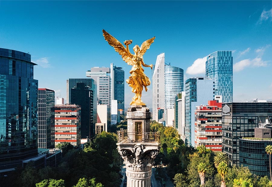 Angel of Independence monument with the Mexico City skyline in the background.