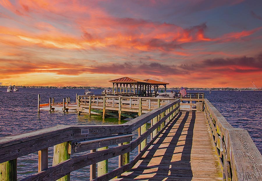 Wooden pier extending into the Indian River Lagoon at sunset near Melbourne, Florida.