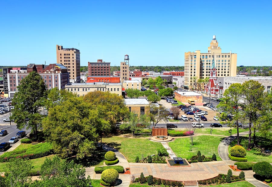 Downtown Monroe, Louisiana, with historic buildings and a landscaped park.
