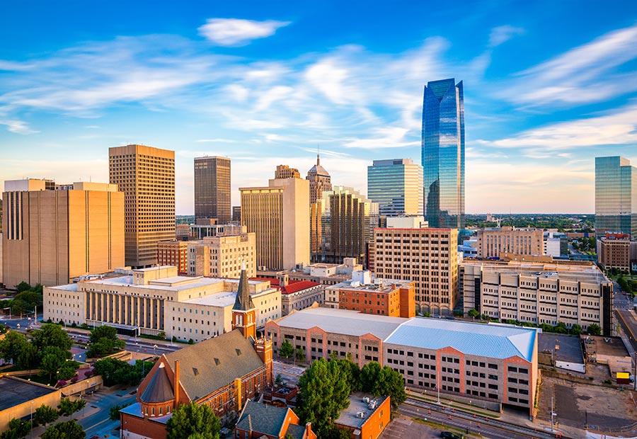 Downtown Oklahoma City skyline with modern skyscrapers under a blue sky.