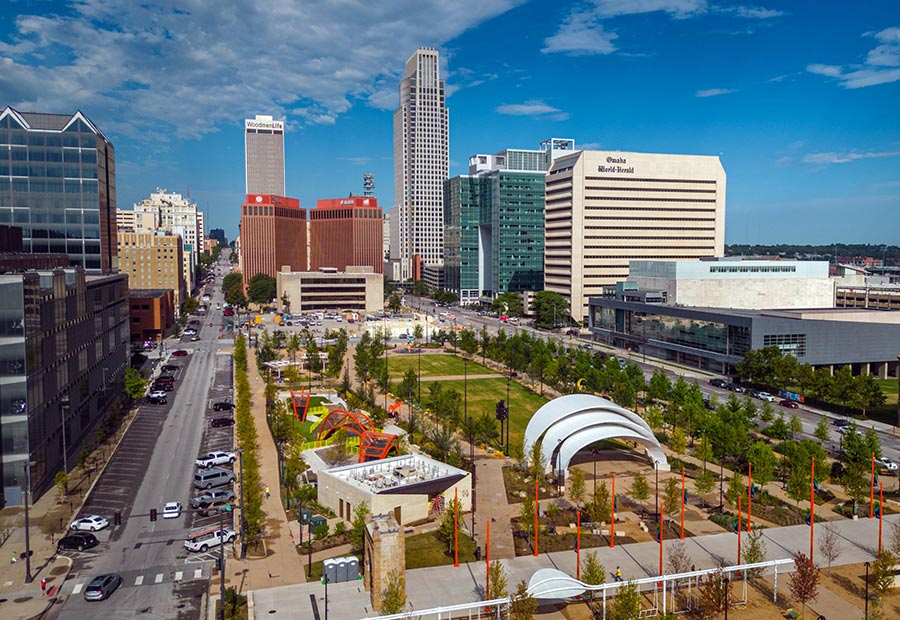 Downtown Omaha skyline and Gene Leahy Mall under a blue sky.
