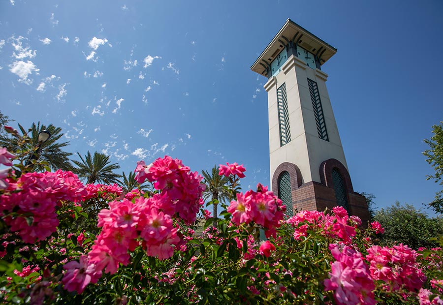Clock tower surrounded by blooming flowers in Ontario, California.