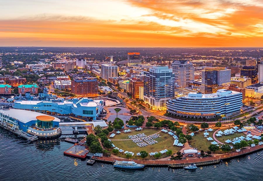 Norfolk waterfront and downtown skyline overlooking the Elizabeth River at sunset.