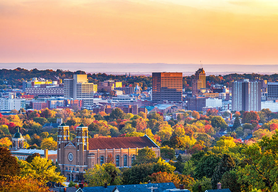 Downtown Syracuse skyline surrounded by autumn foliage.