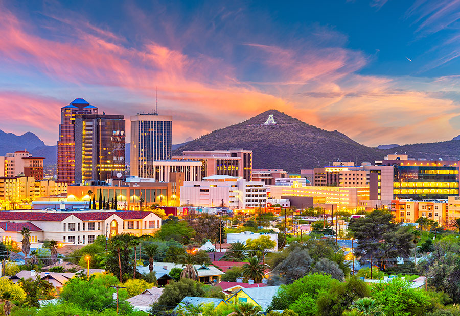 Downtown Tucson with surrounding mountains at sunset.