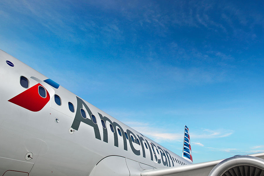 Side view of an American Airlines aircraft under a clear blue sky.