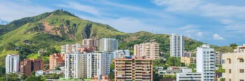 Vista panorรกmica de Cali, Colombia, con la estatua de Cristo Rey. Reserva vuelos a Cali y disfruta de su salsa y clima cรกlido