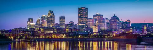 Vista panorรกmica de Montreal, Canadรก, con su arquitectura moderna y el rรญo San Lorenzo. Reserva vuelos a Montreal y descubre su cultura bilingรผe, festivales y vibrante escena gastronรณmica.