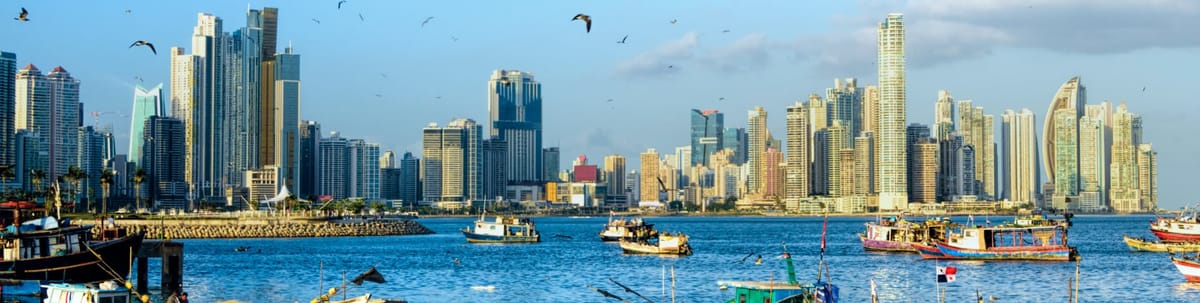 Vista aรฉrea de Ciudad de Panamรก con su skyline moderno y el Canal de Panamรก. Reserva vuelos a Panamรก y explora su vibrante vida urbana y su historia comercial