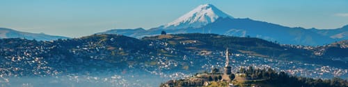 Vista panorรกmica de Quito, Ecuador, con el volcรกn Cotopaxi de fondo. Encuentra vuelos a Quito y descubre su casco colonial y su belleza natural.