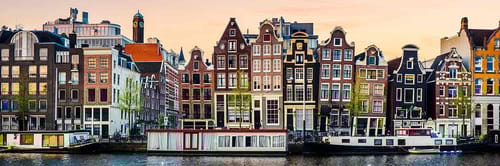 A picturesque scene of the iconic canals and gabled houses of Amsterdam, Netherlands.