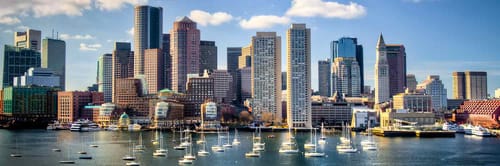 Boston skyline, featuring prominent buildings and the harbor with numerous sailboats