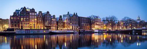 A scenic view of Amsterdam, the capital of the Netherlands, at dusk or night.