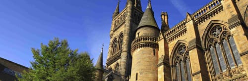 University of Glasgow, in Glasgow, Scotland against a bright blue sky