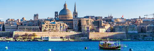 A panoramic view of Valletta, the capital city of Malta, from across the water.