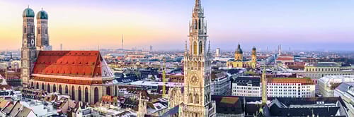 Panoramic view of Munich, Germany, featuring prominent landmarks such as the Frauenkirche (Cathedral of Our Lady)