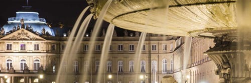 Schlossplatz in Stuttgart, Germany, featuring the New Palace in the background and a fountain in the foreground.