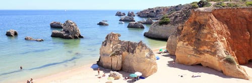 A scenic beach with distinctive rock formations, located in the Algarve region of Portugal.