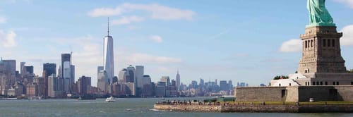 Statue of Liberty on Liberty Island in New York Harbor, with the Manhattan skyline, including One World Trade Center
