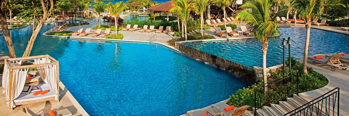 Pool surrounded by lounge chairs at Dreams Las Mareas Costa Rica