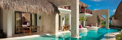 Exterior of a bungalow style resort suite with a large swim out pool at Secrets Cap Cana Resort & Spa