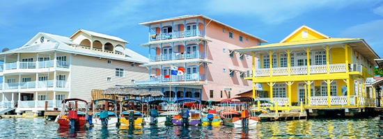Casas de colores junto al agua y pequeñas embarcaciones frente a la costa en Bocas del Toro, Panamá.