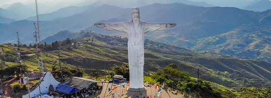 Gran estatua blanca en el Cerro de Cristo Rey con vista a la ciudad de Cali.