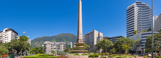 Obelisco de Altamira rodeado de edificios modernos y zonas verdes en Caracas, Venezuela.
