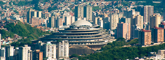 Vista panorámica de El Helicoide rodeado de edificios y laderas urbanas en Caracas, Venezuela.