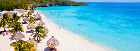 Playa Cas Abao con arena blanca, mar tranquilo y palmeras frente al Caribe en Curazao.