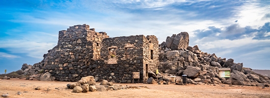Ruinas de piedra de Bushiribana sobre un paisaje árido y rocoso en Aruba.