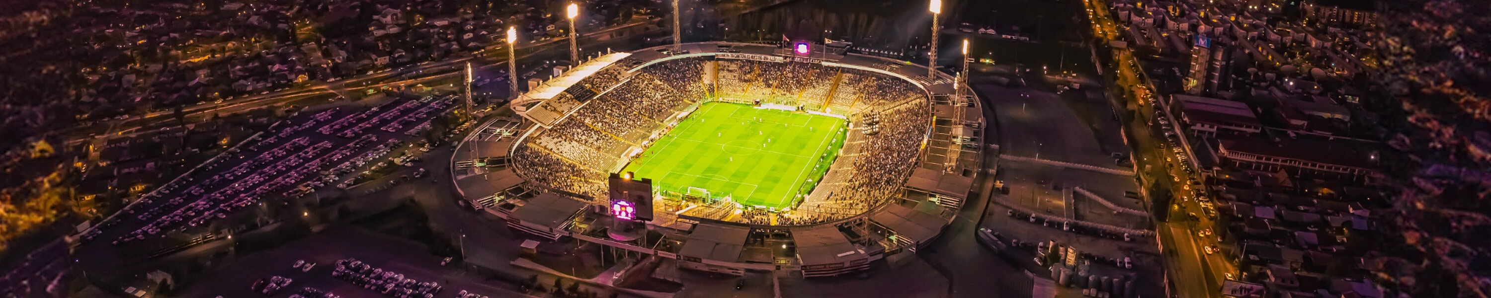 A giant arena during a game at sunset.