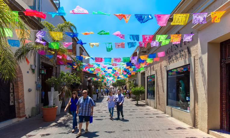 People strolling through a street in Tlequepaque on a sunny day.