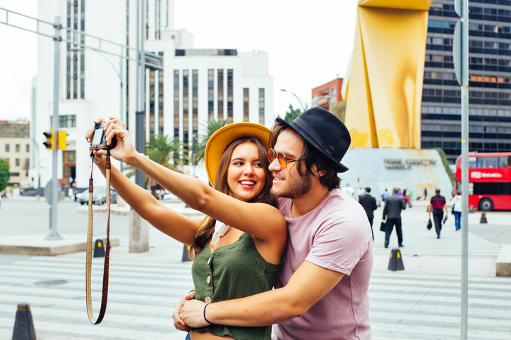 Joven pareja feliz tomando una selfie en el centro de la Ciudad de México.