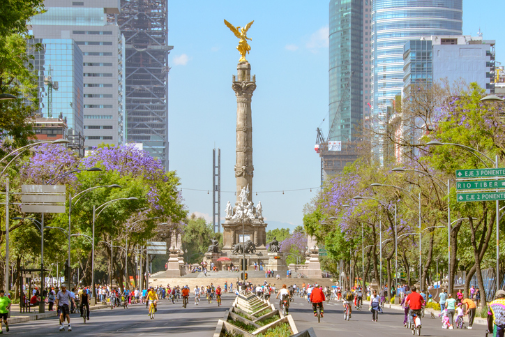 Bike riders through the main avenue of Plaza de la Reforma, with the statue of Independence Angel in the background.
