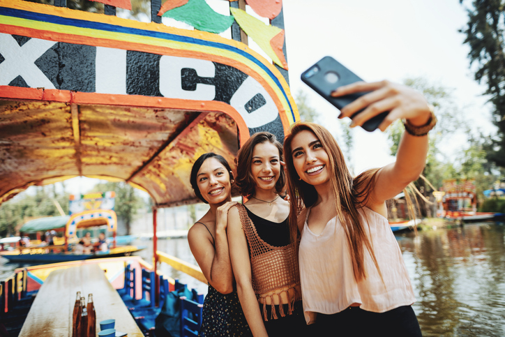 Three girls taking a selfie on a boat in Xochimilco.