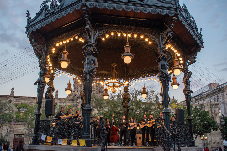 A mariachi band playing on an illuminated kiosk in Guadalajara’s historic center.