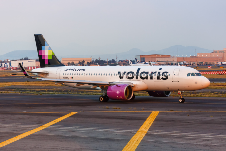 Volaris airbus landing in Mexico International Airport at sunrise.