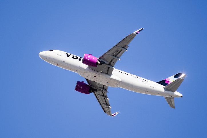 Avión de Volaris visto desde abajo sobre un cielo azul.