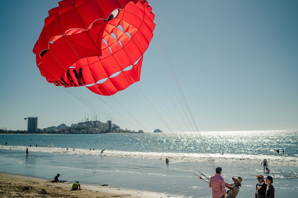Un grupo de personas se prepara para andar en parapente en la Bahía de Mazatlán.