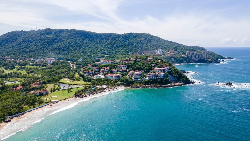 Vista aérea de las costas de Ixtapa, con sus múltiples resorts de la zona hotelera y un arrecife al fondo.