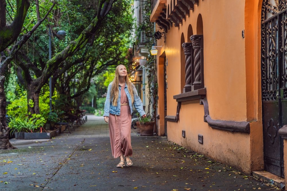 Turista caminando por las calles de Condesa, admirando las fachadas de edificios.