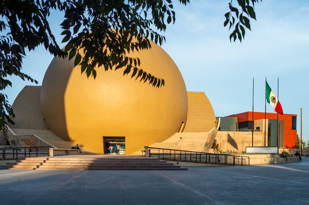 La fachada del CECUT iluminada por el sol del atardecer.
