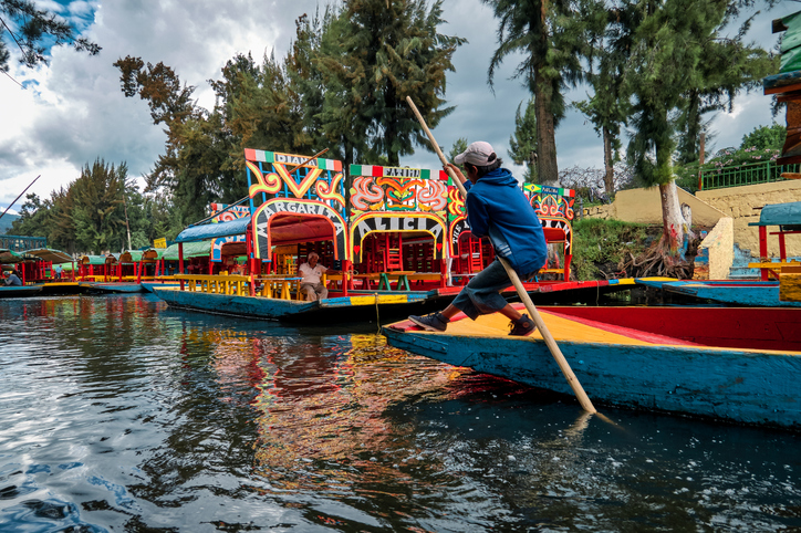A young boy sailing on a trajinera down the Xochimilco canals.