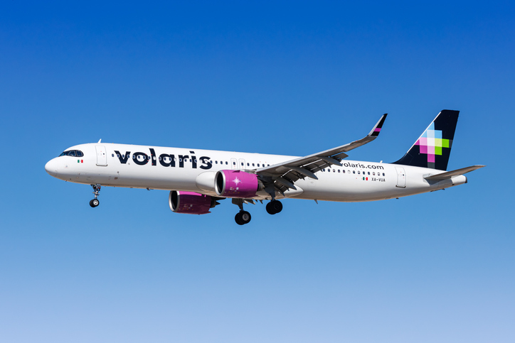 Volaris airbus flying across a blue sky.