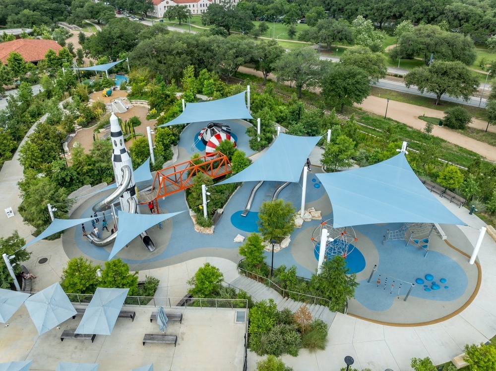 Vista Aéreas del parque de juegos Space Adventure en Houston con réplicas de cohetes, estructuras de sombra en Hermann Park cerca de Japanese Garden