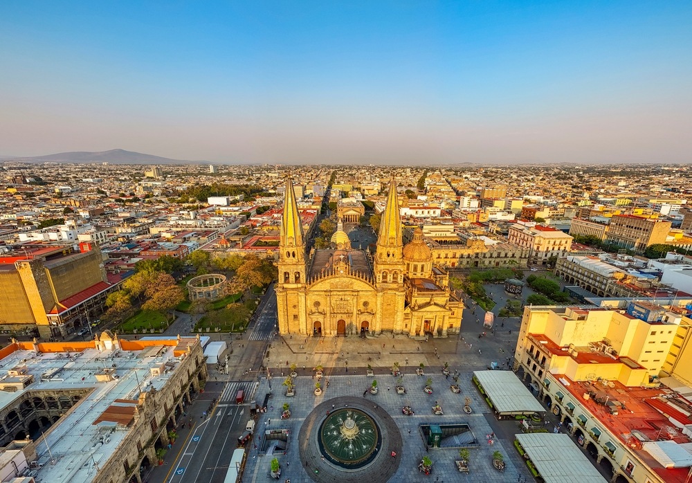 Una foto aérea panorámica capta la impresionante fachada de la Catedral de Guadalajara al atardecer.